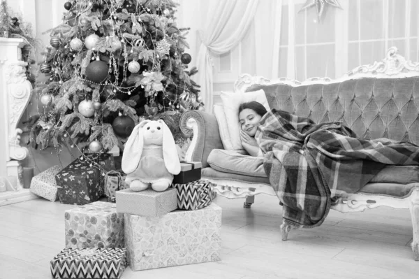Geloof in wonderen. Magisch moment. Kerstavond. Gelukkig nieuwjaar. Familie vakantie. Kerstboom en cadeautjes. Dromen over geschenken. klein meisje slapen bank in de buurt van kerstboom klassiek interieur — Stockfoto