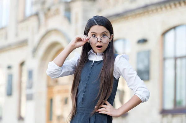 Ena! Criança surpreso olhar através de óculos com a boca aberta. De volta à moda escolar. Uniforme escolar. Educação formal. Surpresa em aprender. Ensino privado. Conceito de educação. Muito surpreendente. — Fotografia de Stock