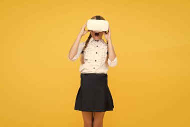 Yeni gerçekliğin tadını çıkar. Mutlu çocuk modern teknoloji kullanıyor. Gelecekteki eğitim. Okula dönüyorum. Dijital gelecek ve yenilik. Sanal gerçeklik. VR kulaklıklı küçük kız. Küçük çocuk kablosuz VR gözlük takıyor