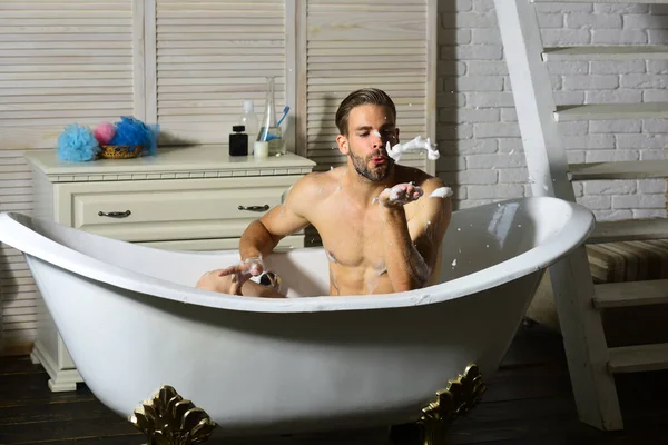 Guy neemt bad met toiletartikelen en trappen op de achtergrond — Stockfoto
