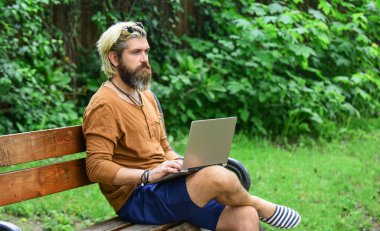 Evde eğitim kavramı. Online uzak eğitim. Hipster parkta ilham kaynağı oldu. Çevik iş. Bilgisayarda çalışan olgun bir öğrenci. Pazartesi günü siber alışverişe git. Sakallı adam dizüstü bilgisayarla bankta oturuyor.