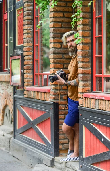 Açık havada fotoğraf çekimi. Geçmişe dönük kamerası olan vahşi bir gezgin. Modern hayatta fotoğrafçılık. Seyahat ipuçları. Profesyonel fotoğrafçı klasik kamera kullanır. Sakallı hippi adam fotoğraf çek.