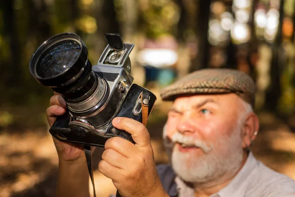 Photo shoot session. man holding old classic camera. Man with retro photo camera. Travel Lifestyle outdoor. Photographers choosing it. man holds an old vintage film camera. holiday in forest — Stock Photo, Image