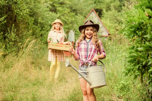 Kertészek dolgoznak. gyerektartó kerti szerszámok. Kislány farmer lapáttal és öntözőkannával. Boldog gazdálkodást. Tavaszi vidék. szelektív fókusz. ökológia védelem. Földi nap. nyári gazdaság — Stock Fotó
