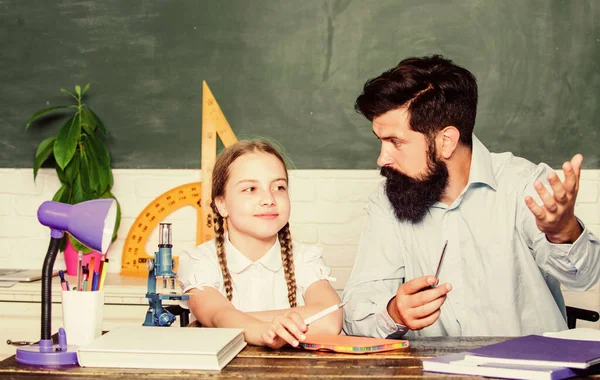 Wat een interessant boek. Vader en dochter studeren in de klas. terug naar school. Wiskunde geometrie. biologie scheikundeles. onderwijs en kennis. bebaarde man leraar met klein meisje in de klas — Stockfoto