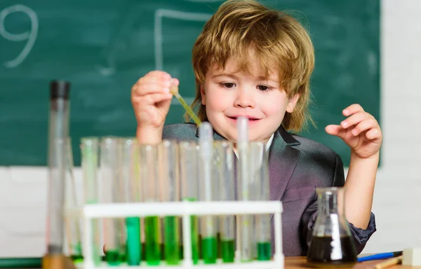 Jongen gebruikt microscoop reageerbuizen chemie school klaslokaal. Hij studeert scheikunde. Biotechnologie en farmacie. Geniale leerling. Chemische analyse. Wetenschapsconcept. Wunderkind experimenteert met chemie — Stockfoto