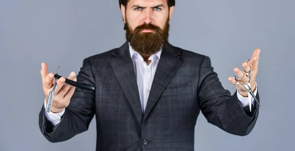 Hombre guapo. Maestro peinando pelo y barba en la barbería. peluquería hace peinado. Retrato de moda de hipster. hombre guapo con larga barba de pelo oscuro y bigote mantenga hoja de afeitar retro —  Fotos de Stock