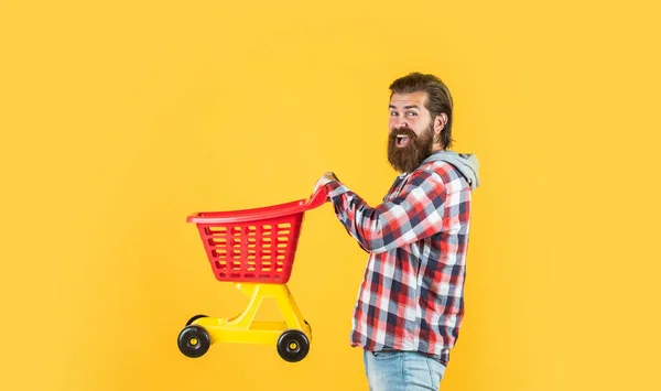 Man go shopping. funny man with small shopping cart. weekend on buying products. rejoices successful purchases. brutal mature hipster go shopping. Its time to fill the cart — Stock Photo, Image