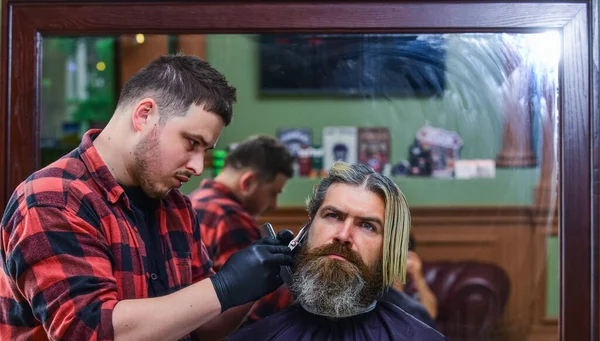 Torne-se um super-herói barbeiro. cliente visitando cabeleireiro. Hora do novo corte de cabelo. o homem olha para o reflexo do espelho. homem bonito maduro com cabelo. barbeiro ou ferramenta de cabeleireiro. hipster brutal na barbearia — Fotografia de Stock