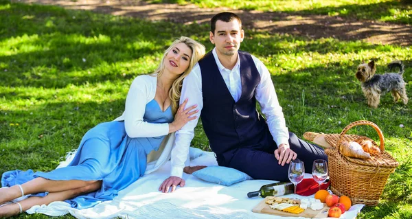 Deep in love. picnic of couple in love with dog. family relationship and friendship. nice summer holiday. girl and man travel together. couple in love drinking wine during romantic dinner in park