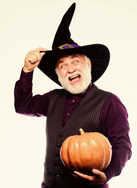 Senior man white beard celebrate Halloween with pumpkin. Magic