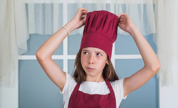 작은 소녀는 요리 모자를 쓰고 요리를 한다 — 스톡 사진
