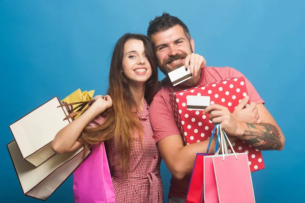 Para w miłości przytula się trzymając torby na zakupy i karty kredytowe — Zdjęcie stockowe