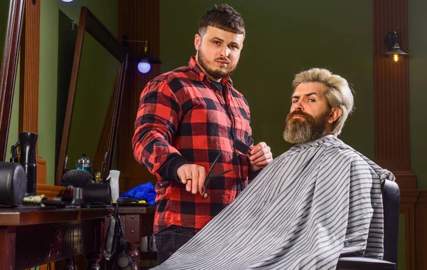 Pekerjaan menata rambut profesional. Gaya hidup. tukang cukur master tidak gaya rambut dengan pengering. Konsep Barbershop. Pemuda hipster dengan jenggot memotong rambutnya di salon. Terbuka dan ramah — Stok Foto