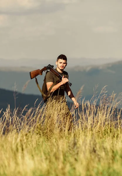 Hunter segura na espingarda. Belo dia para caçar. Hunter passa a caça ao lazer. Caminhando nas montanhas. Caçando conceito de hobby masculino. Homem brutal gamekeeper natureza paisagem fundo. Regulamento de caça — Fotografia de Stock