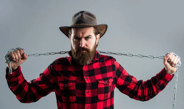 Gebt nicht auf. angekettet in Ketten. Der bärtige Mann hat ein aggressives Aussehen. Ausdruck seiner Stärke. männliche Macht und Männlichkeit. Reife Hipster brechen Kette. Fesseln. Brutaler Mann mit Cowboyhut und Kette — Stockfoto