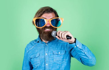 Müzik sadece kelimeleri arayan aşktır. Oyuncu eğleniyor. Komik parti gözlüklü olgun sakallı adam şarkı söyler. Mikrofonlu vahşi erkek hippi. vokal okulu. favori müzik tarzı