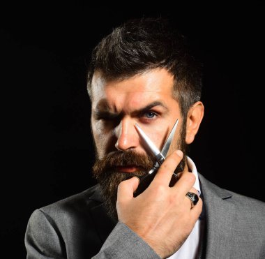 Uzun sakallı adam çelik makas tutuyor. İş ve berber dükkanı