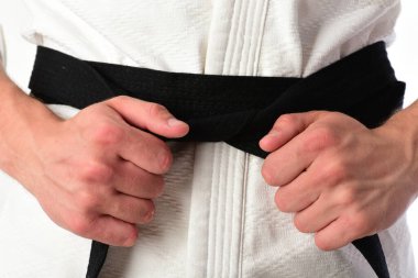 Adam siyah kuşaklı beyaz kimonoyla poz veriyor..