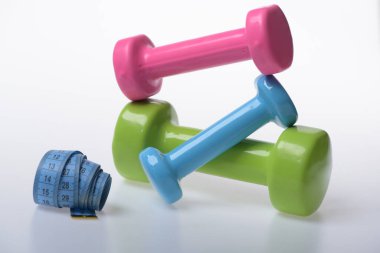Mezura ve pembe, yeşil ve mavi halterler.