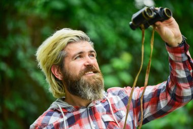 Daha yakından bakalım. Dürbünlü bir adam ormanda teleskop kullanıyor. Seyahat konsepti. uzak geleceğe bakmak. Hobi ve rahatlama. Dürbünlü bir turist ormanda bir şeyler arıyor.