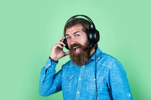 Glada man bär moderna hörlurar. Man i hörlurar lyssnar musik. E-bok och elärande koncept. utbildning på nätet. Företagskurs på nätet. hans favoritlåt — Stockfoto