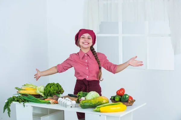 Niño alegre prepara la ensalada de hortalizas en la cocina, la comida orgánica — Foto de Stock