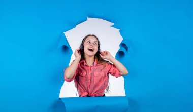 Ne güzel bir gün. Dijital çağda yaşamak. Genç çocuk müzik dinler. Çocuk dinleme kitabı. Elderning kavramı. Modern cihazlarla çevrimiçi eğitim. Kız kulaklık takıyor. iyi kalite ses