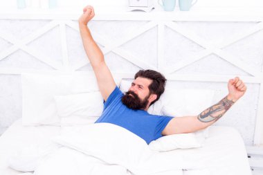 Güzel bir sabah. Tembel pazar. Yatak zamanı rutini. Vahşi erkek esneme hareketleri. Rahat yaşam tarzı konsepti. Yatakta sakallı bir adam. Sabah erken kalkarım. Bekar rahat hisset. Adam yatak odasında dinleniyor.