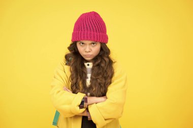 Okuldan nefret ediyorum. Sarı arka planda mutsuz bir çocuk. Sevimli küçük çocuk resmi okul üniforması giyiyor. Sonbahar modasında uzun kıvırcık saçlı sevimli küçük bir kız. Çocuk okula hayır diyor.