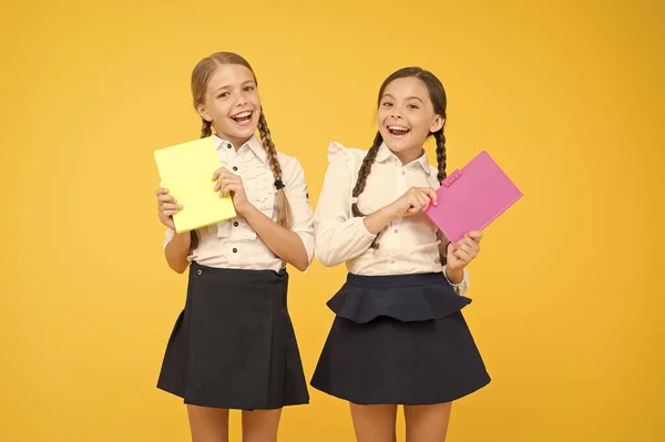 Au-delà du Livre. Des petites filles en uniforme scolaire. camarades de classe joyeux avec cahier d'exercices. carnet de dictionnaire. Obtenir des informations. lire l'histoire. littérature pour enfants. Les enfants apprennent la grammaire. retour à l'école — Photo