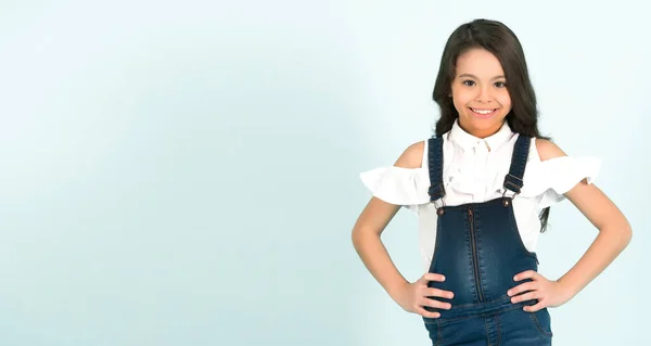 Niña sonrisa en jeans en general con las manos en la cadera — Foto de Stock