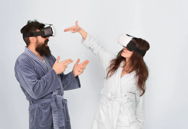Kezeket fel! Álljon fel és szállítsa. VR technológia és jövő. VR kommunikáció. Izgalmas benyomások. Egy pár fürdőköpenyben visel VR szemüveget. Játék és szórakozás. Férfi és nő fedezze fel a VR otthon — Stock Fotó