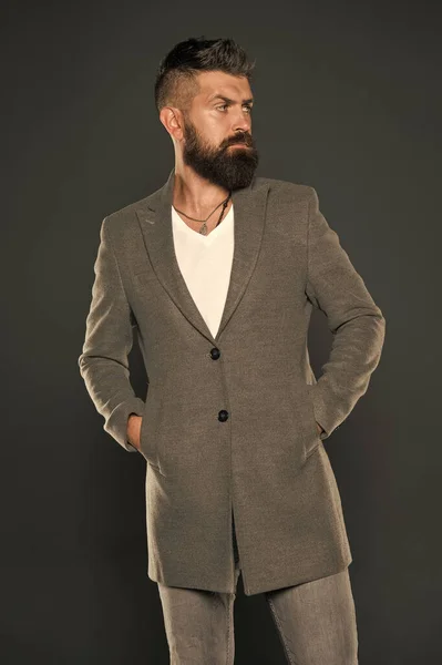 Serious concentrated man. Caucasian man with brutal appearance. Bearded man with moustache and beard on unshaven face in brutal style. Brutal hipster wearing casual outfit. Comfortable simple coat — Stock Photo, Image
