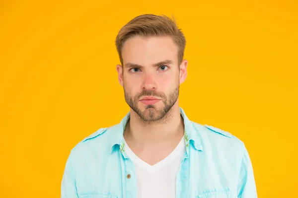 Bonito homem sem barba com cerdas. estilo de moda casual verão masculino. cara sério tem o cabelo preparado no fundo amarelo. emoções humanas. sexy menino com moderno penteado desgaste camisa — Fotografia de Stock