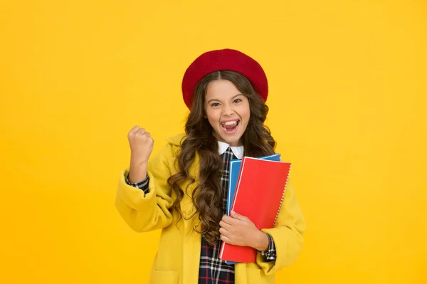 ¡Hurra! niño feliz en uniforme de alumno. niño en boina francesa sobre fondo amarillo. estudiante universitario adolescente con estilo. niña con cuaderno o cuaderno para la lección. concepto de educación. escuela y moda — Foto de Stock