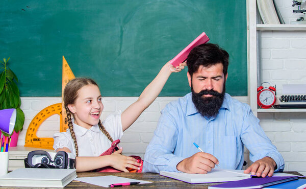 Help study. Study is fun. School teacher and schoolgirl. Homeschooling with father. Man bearded pedagogue study together with kid. Discipline and upbringing. Reward and punishment principle