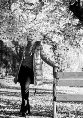 Sonbahar sezonu konsepti için ceket. Sonbahar parkında makyajcı bir kadın. Kız kırmızı parlak, kalın bir ceket giyiyor. Sonbahar moda konsepti. Çekici kadın ceketle poz veriyor.