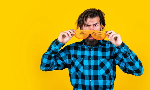 Förvånad skäggig man bär roliga fest glasögon på gul bakgrund, kopiera utrymme, fest goer — Stockfoto