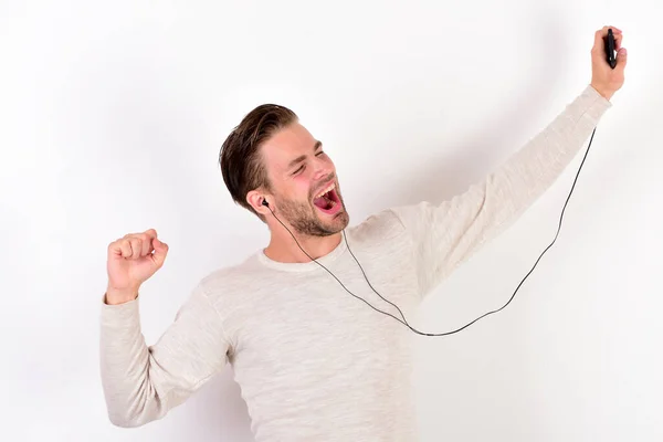 Jovem alegre usando fones de ouvido e ouvindo música — Fotografia de Stock