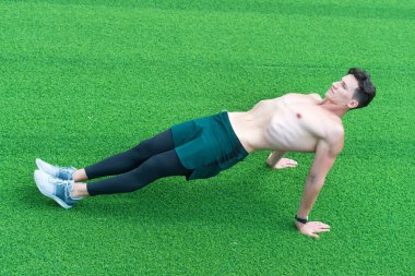 Ters kalas belini güçlendirir, adam dışarıda egzersiz yapar.