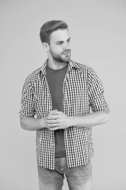 Günlük hayat için kıyafetler. Yakışıklı, tıraşsız bir yüz ve şık saçlar. Beyaz adam sarı arka plan. Modern gündelik tarzda sakallı adam. Yakışıklı bir erkek portresi. Yüz kılı ve cilt bakımı konsepti