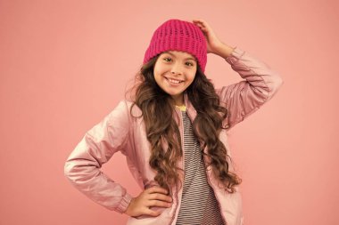 Aksesuar dükkanı. Kaygısız ve mutlu. Küçük çocuk kabarık ceket ve örgü şapka giyiyor. Kış alışverişi. Mutlu bir çocukluk. Moda bir aksesuar. Yumuşak bir stil. Kışın kalın giyin. Soğuk kışa hazırım.
