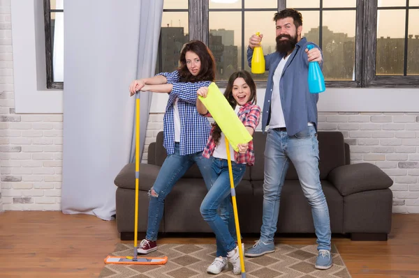 Mother father and little girl child cleaning home with mops and sanitizers