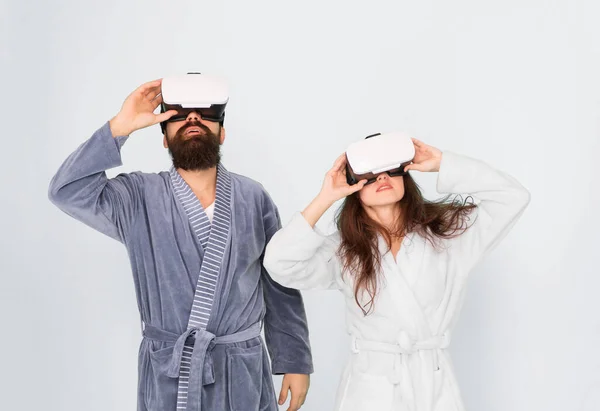 Mañana comienza con la tecnología del futuro. pareja digital. innovación en las relaciones familiares. crear su realidad. Nuevo mundo de realidad virtual. pareja familiar usan auriculares vr. chica y hombre relajarse en albornoz — Foto de Stock