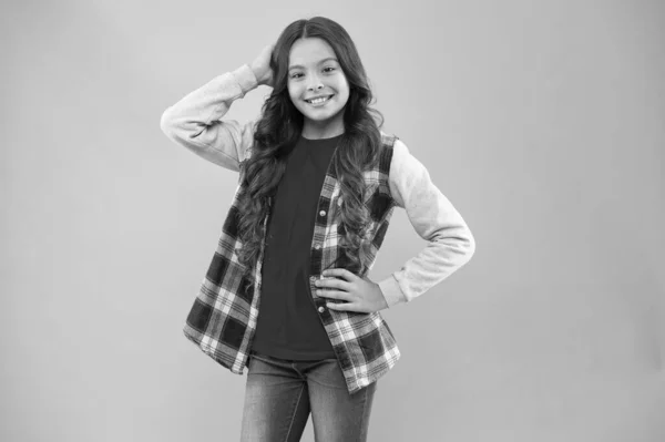 Feliz dia das crianças. Menina rosa espaço cópia de fundo. Adolescente promovendo roupas de moda. Moda infantil. Miúda da escola sorridente. Cabelo encaracolado comprido. Menina pequena usar camisa xadrez. Criança feliz — Fotografia de Stock