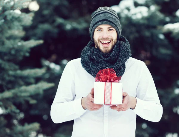 Handsome man with present box in winter outdoor — Stock Photo, Image