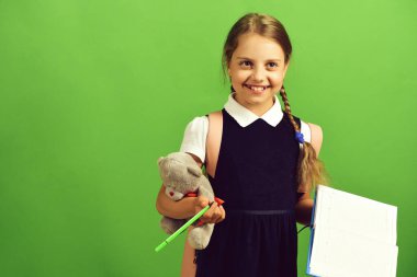 Okul üniformalı, örgülü ve sırt çantalı bir öğrenci.