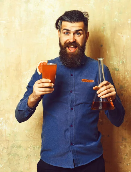 Brutalny hipster trzymający kieliszek i szklaną rurkę lub kolbę — Zdjęcie stockowe