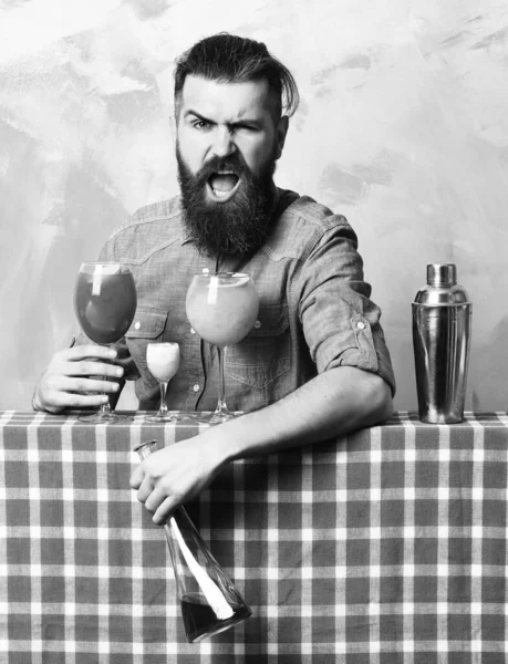 Brutal caucasian hipster with alcoholic cocktails and bar stuff